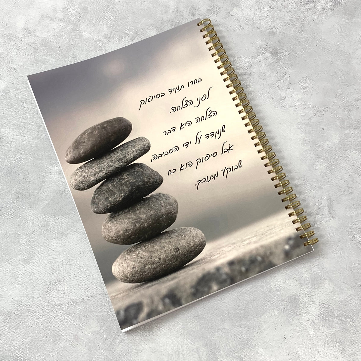 מחברת ספירלה גדולה לאישה ולגבר בצבע שחור עם הכיתוב: סיפוק לפני הצלחה