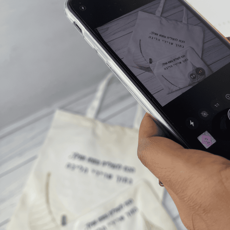 תיק קנבס נולדת דגם הכח להצליח עם משפט מעצים כתב בצבעים שחור תיק בגוון לבן ושמנת עם ציור של עלה שחור