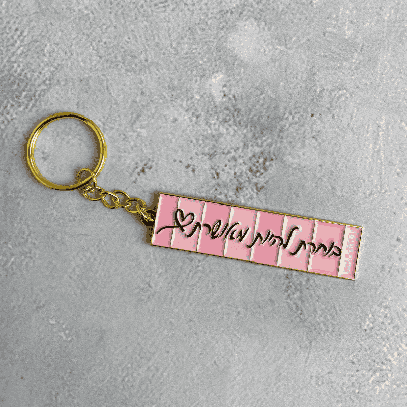 מחזיק מפתחות דגם בוחרת להיות מאושרת כיתוב בשחור המחזיק מוזהב ורקע המחזיק בגווני ורוד בפסים