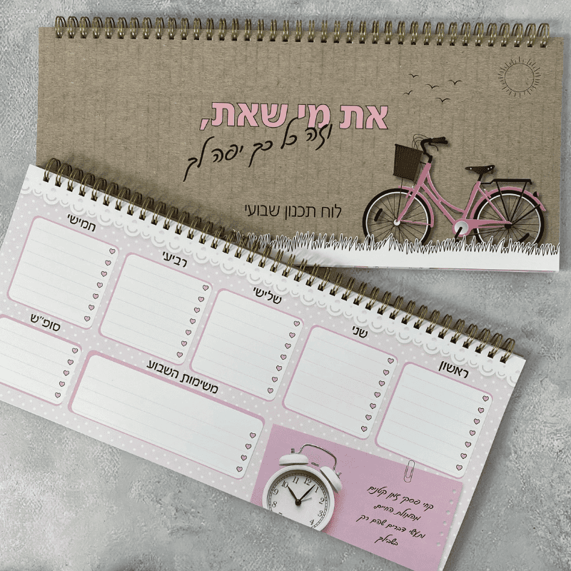 לוח תכנון שבוע דגם את מי שאת עם משפט מעצים רקע חום קרטון עם ציור של אופניים ורודות על דשא לבן