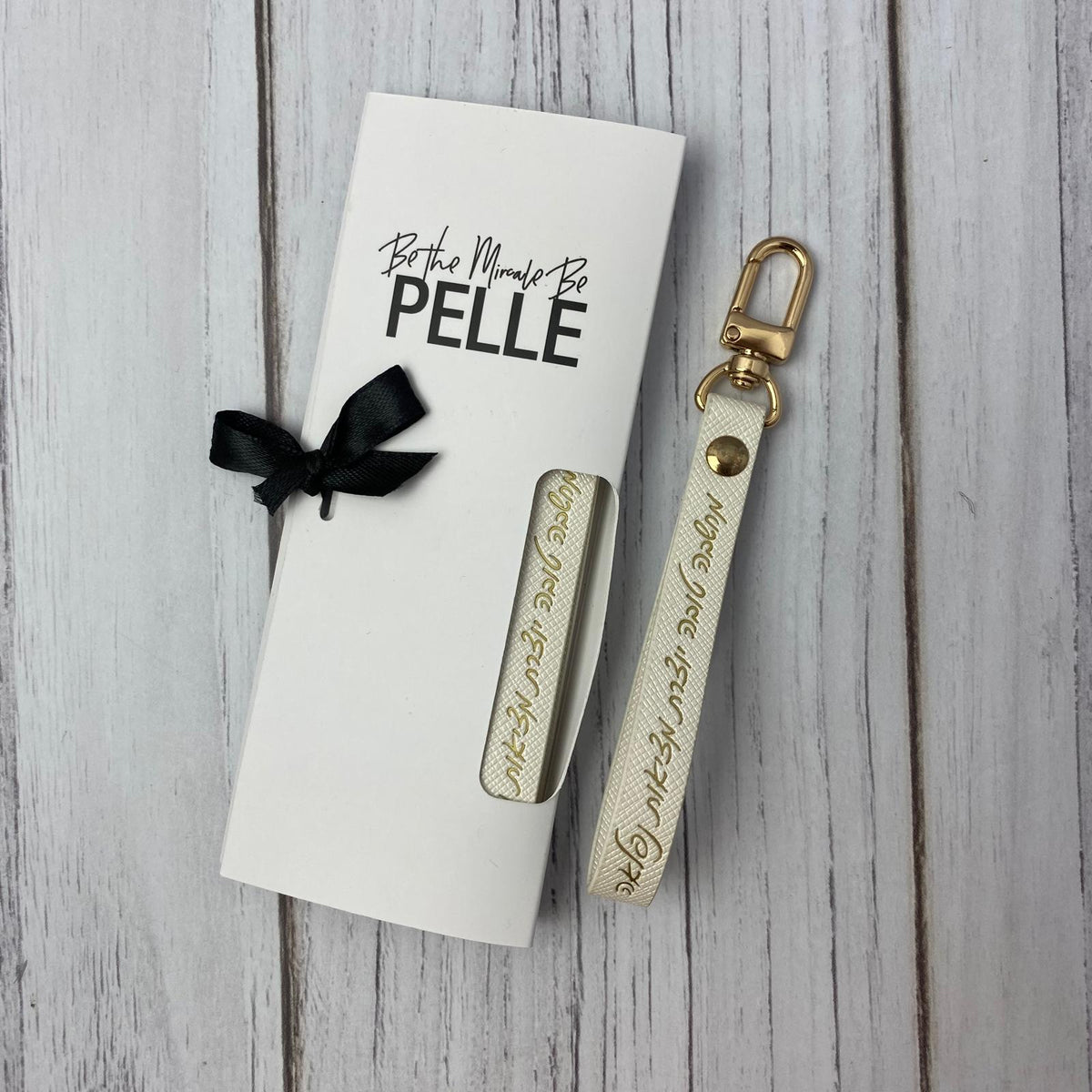 מחזיק מפתחות לבן לנשים עם הכיתוב: מחשבה טובה יוצרת מציאות נפלאה