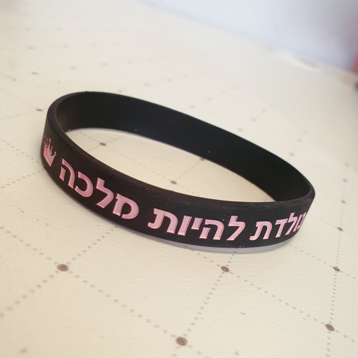 צמיד סיליקון שחור עם הכיתוב: נולדת להיות מלכה