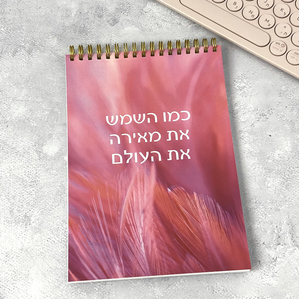 מחברת ספירלה בעיצוב צבעוני עם הכיתוב: כמו השמש את מאירה את העולם