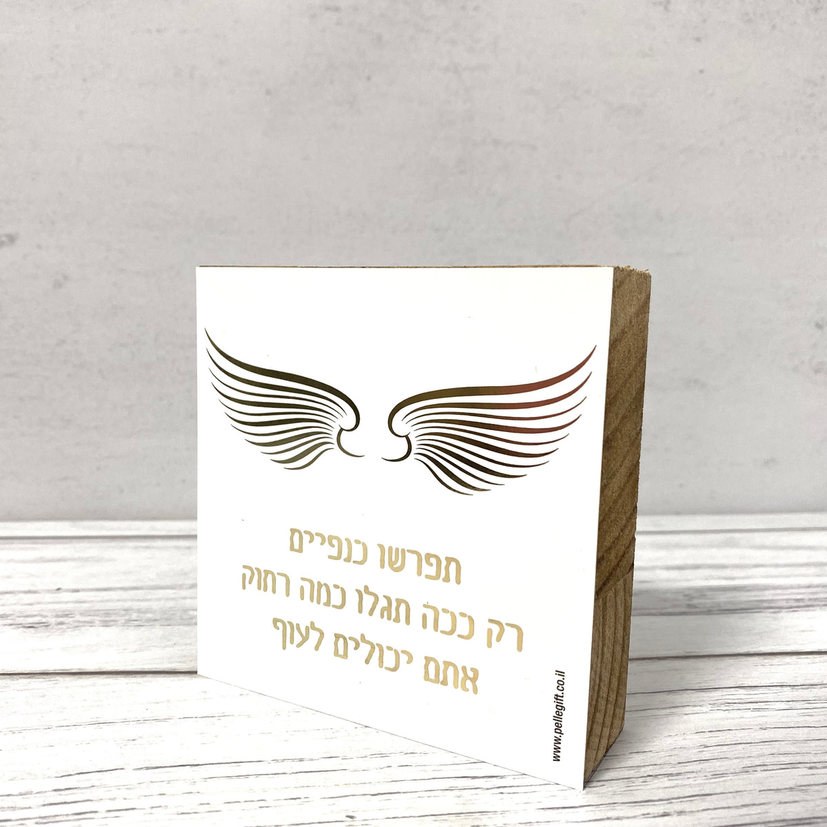 בלוק עץ אגוז ריבוע קטן עם הכיתוב: תפרשו כנפיים
