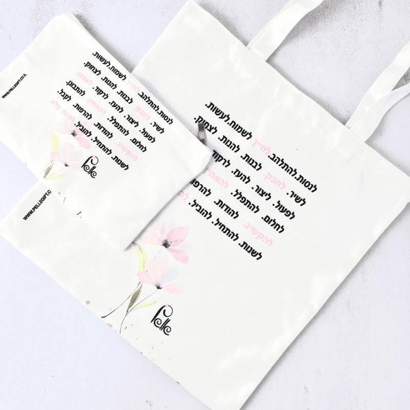 תיק קנבס עם משפט מעצים כיתוב בצבע שחור ורוד רקע לבן עם ציור של פרחים ורודים
צד אחורי