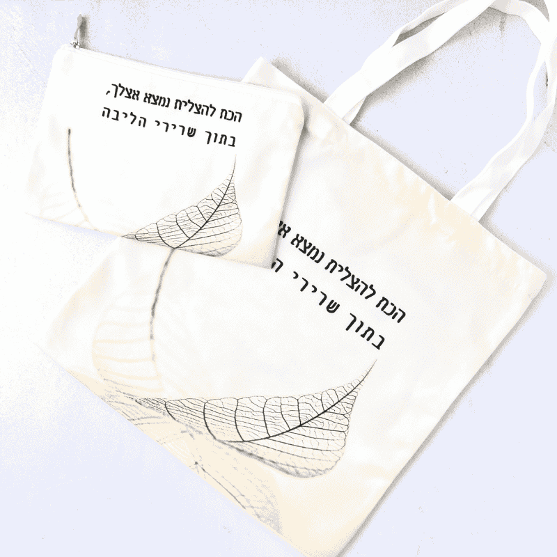 תיק קנבס נולדת דגם הכח להצליח עם משפט מעצים כתב בצבעים שחור תיק בגוון לבן ושמנת עם ציור של עלה שחור